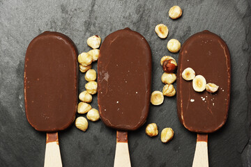 top view of chocolate ice cream on slate plate with hazelnuts. flat lay