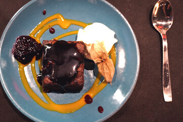 top view of brownie on blue plate with cream. flat lay flat design