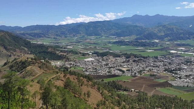 Astonishing daytime wide angle panning shot of a mountain town view in the Constanza Valley in Dominican Republic