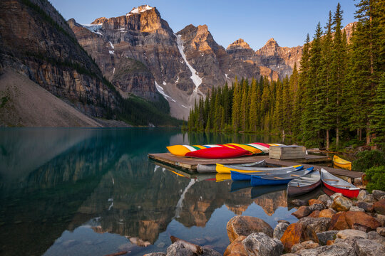 Canoes moored at Moraine Lake Dock with mountains in background