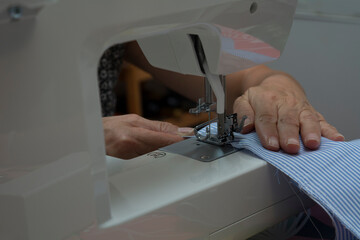 MANOS DE MUJER COSIENDO A MAQUINA