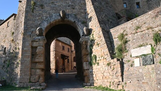 Volterra, tuscany, Italy. August 2020. One of the Etruscan access doors to the historic center. People cross the passage, some stop to observe it.