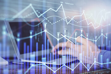 Double exposure of man's hands holding and using a digital device and forex graph drawing. Financial market concept.