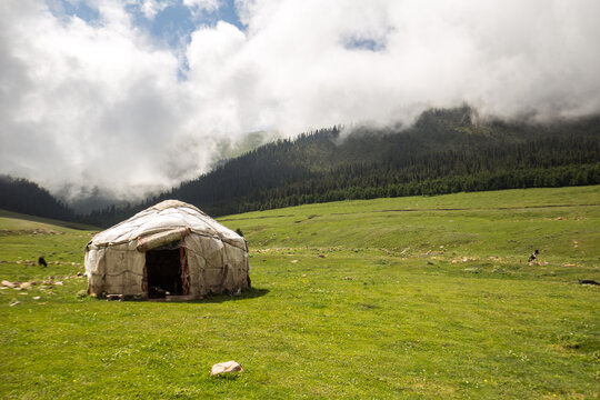 View of yurt on grassy landscape in Kyrgyzstan