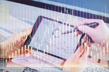 Double exposure of man's hands holding and using a phone and financial chart drawing. Market analysis concept.