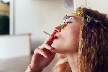 Young blonde caucasian woman standing outdoor with cigarette - Beautiful girl smoking joint in...