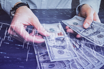 Multi exposure of financial graph drawing hologram and USA dollars bills and man hands. Analysis concept.