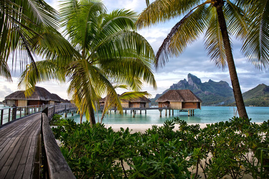 Scenic view of stilt bungalows in sea with Mount Otemanu in background