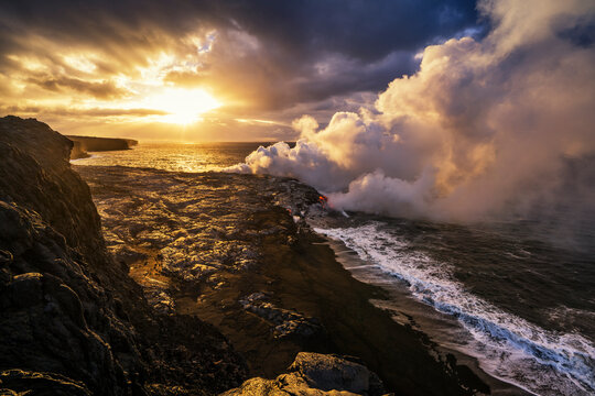 Molten lava flowing in Pacific Ocean during sunrise