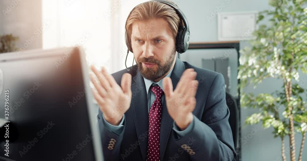 Aufkleber successful businessman in headset talking and gesturing during working conversation on modern comput