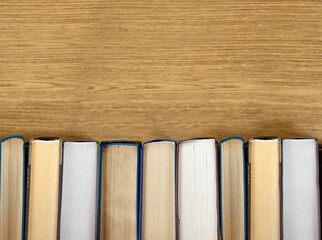 Old books on a wooden shelf with blurred backgrund