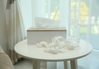 Used paper tissues, holder and water on table indoors