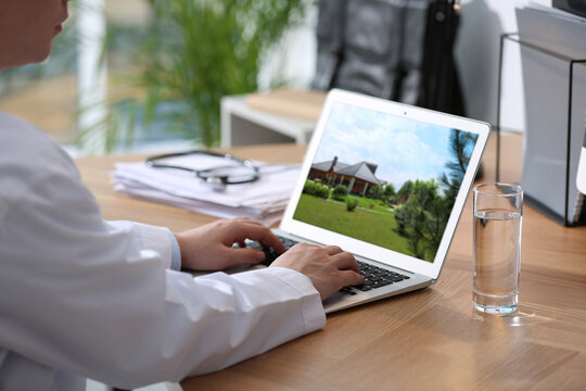 Real estate agency online service. Doctor choosing new house via laptop, closeup