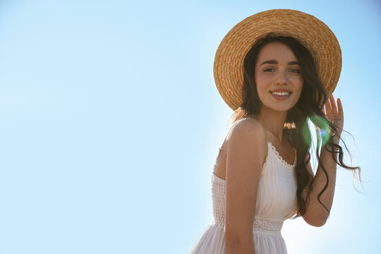 Happy Young Woman With Beach Hat Against Blue Sky On Sunny Day