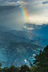 formation of a rainbow in the middle of a storm over the mountains of colombia	