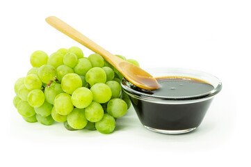 Bunch of fresh green grape and grape molasses in glass bowl  isolated on white background, clipping...