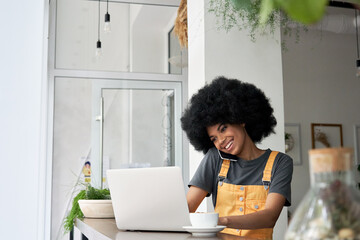 Happy young adult hipster African American woman, female student with afro curly hair holding...