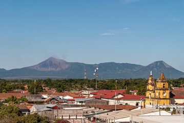 Leon, Nicaragua - November 27, 2008: Cathedral of Assumption, Asuncion. Smoking Telica volcano in...