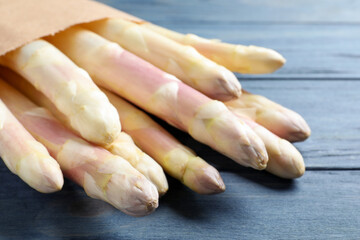 Fresh white asparagus on blue wooden table, closeup