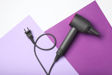 Hair dryer on color background, top view. Professional hairdresser tool