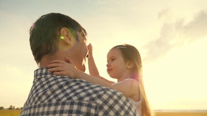 Dad hugs happy little daughter in summer park. Father and little child play together, laugh and hug. happy family travel. healthy baby in arms of father. Dad is off. Happy family and childhood concept
