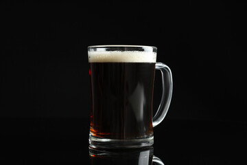 Glass mug of delicious kvass on black background