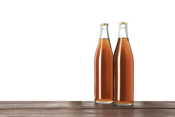 Bottles of delicious kvass on wooden table against white background