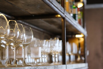 close up empty drinking glasses on retro wooden shelf in bar. blur background