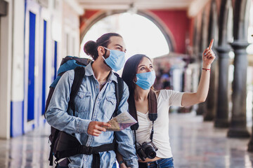 latin young couple tourists with face mask on vacation in Mexico Latin America in coronavirus...