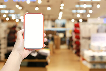 Hand of a man holding smartphone device in the Shopping mall background.