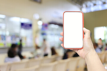 Hand of a man holding smartphone device in the hospital blur background.