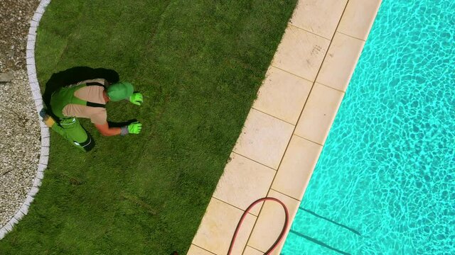 View Of Handy Landscaper Placing Last Piece Of Sod And Completing New Lawn Installation In Private Residence. 