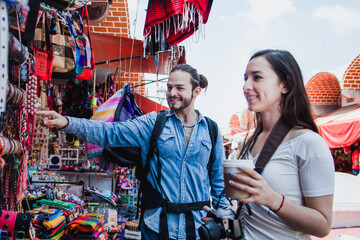 Latin couple backpacker shopping in a Tourist Market in Mexico City, Mexican Traveler in Latin America