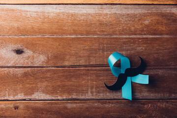 November Blue, Light blue ribbon with a man mustache on wooden background, Movember Men health...