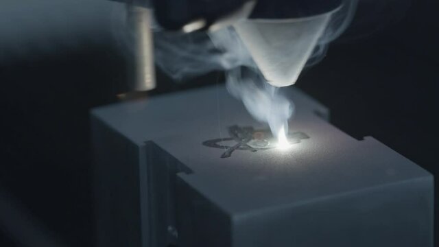 Extreme Closeup High Speed of Laser Engraving Machine Etching Design into Metal Block