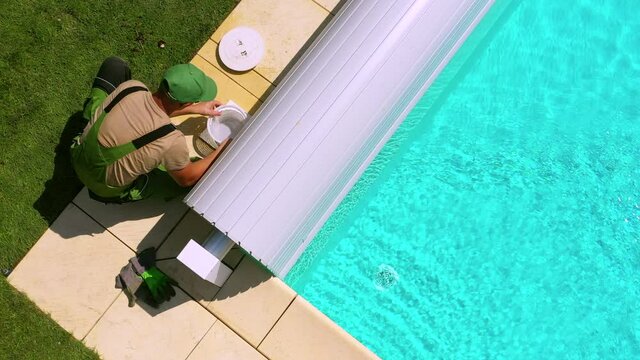 Male Pool Maintenance Worker Removing Swimming Pool Skimmer Basket Full Of Dirt To Rinse And Clean It. 