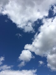 Powerful white and gray clouds in a deep azure blue sky.