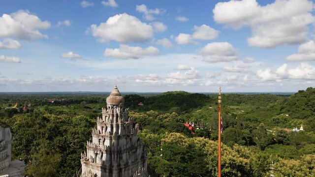 Fly over Buddhist temple Phnom Pros revealing buddha head in Kampong Cham, Cambodia lush countryside