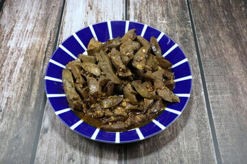 Traditional fried and stirred sliced duck liver with fresh chopped garlic, soy sauce and pepper on the plate. Famous offal menu in Asia restaurant. 