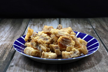 Traditional deep fried chopped pork belly with flour on the plate. Famous crispy and crunchy snack in Asia restaurant. 