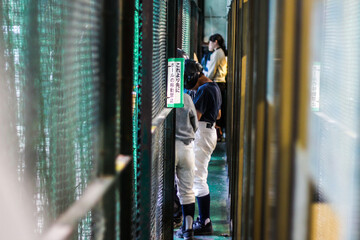 Japanese people waiting in line at a batting cage
