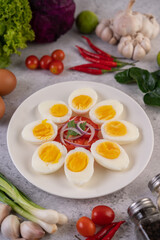 Half boiled egg in a white plate with tomatoes and spring onions.