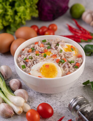 Boiled egg porridge in white bowl.