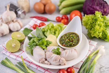 Squid stuffed with cooked pork with seafood sauce.