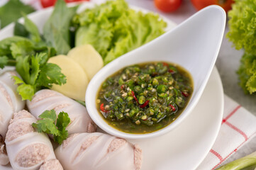 Squid stuffed with cooked pork with seafood sauce.