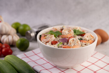 Shrimp Salad with Tomato Red onion and coriander in a white cup.