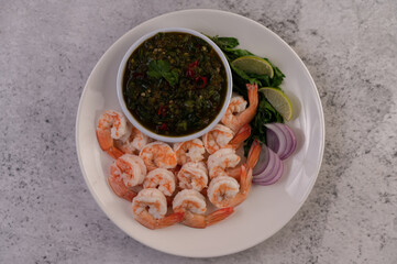 The cooked prawns are arranged in a plate with dipping sauce.
