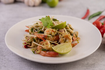 Shrimp cooked with lemongrass, vegetables, lime and chili on a white plate