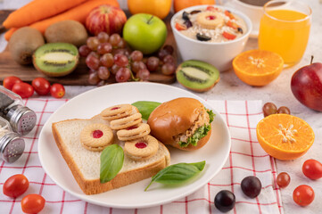 Bread slices, stuffed buns, and burgers on a white plate.