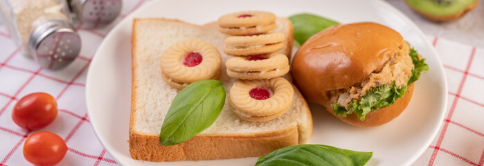 Bread slices, stuffed buns, and burgers on a white plate.